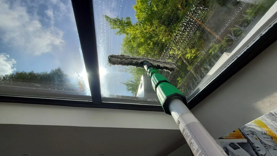 Technicien OSMONET utilisant perche télescopique pour lavage de vitres en hauteur jusqu'au 5ème étage à Nice